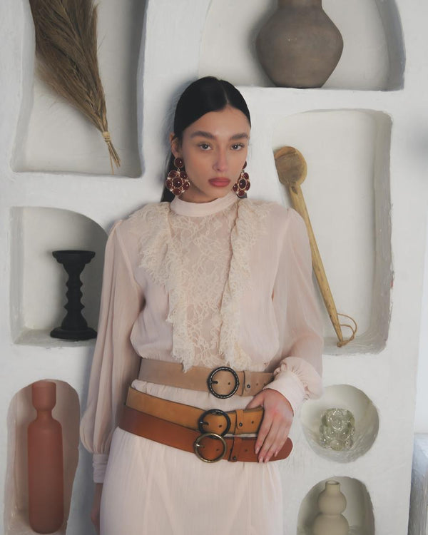 Three Pip belts, taupe, cognac and brown, stacked over a cream lace blouse
